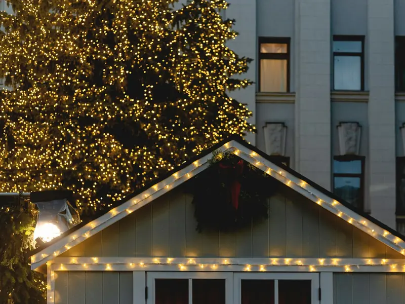 Warm white lights outlining the roof peak of a garage at night