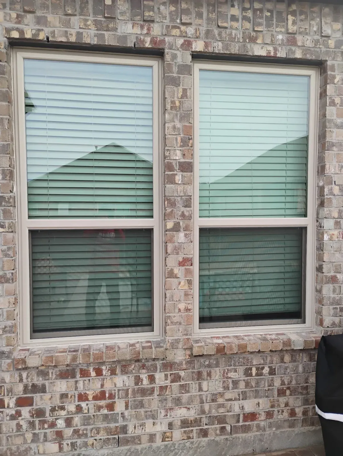 Pair of new almond double-hung windows set in brick at a Bethany Lakes home in Allen