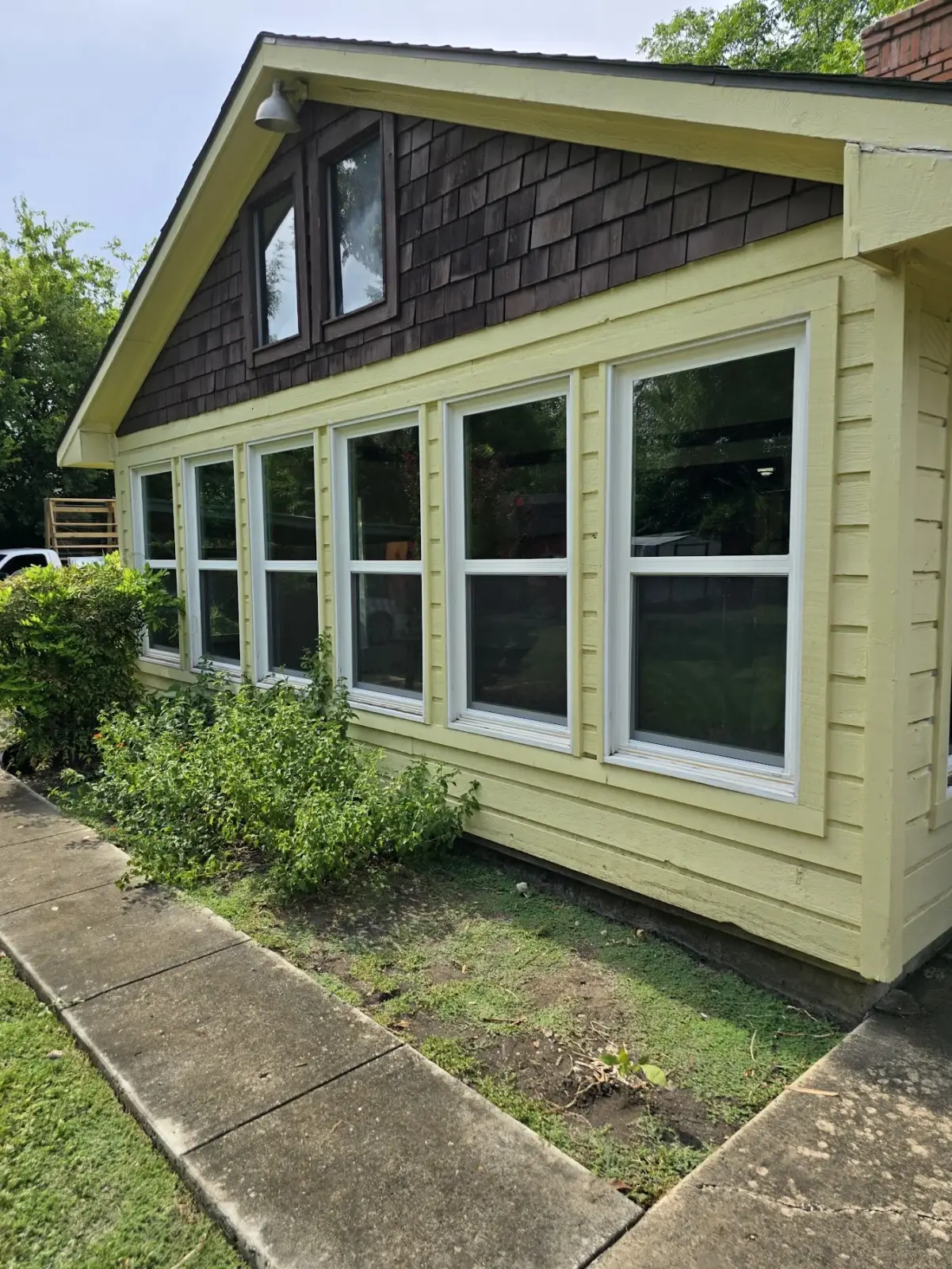 Exterior window wall of new white Vistamark double-hung windows on a Historic Downtown McKinney craftsman bungalow