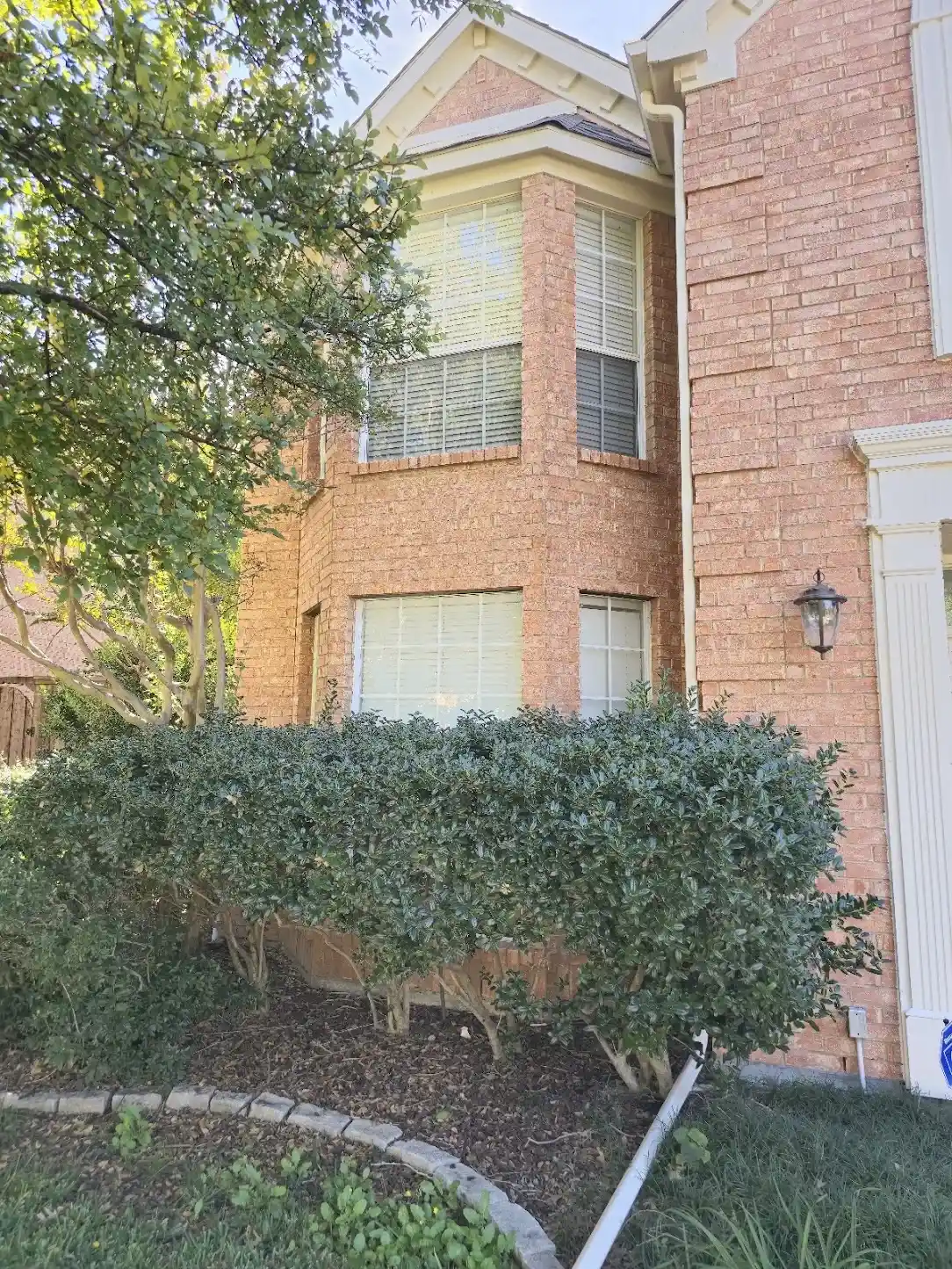 Front bay windows on a West Plano brick home before full-home window replacement
