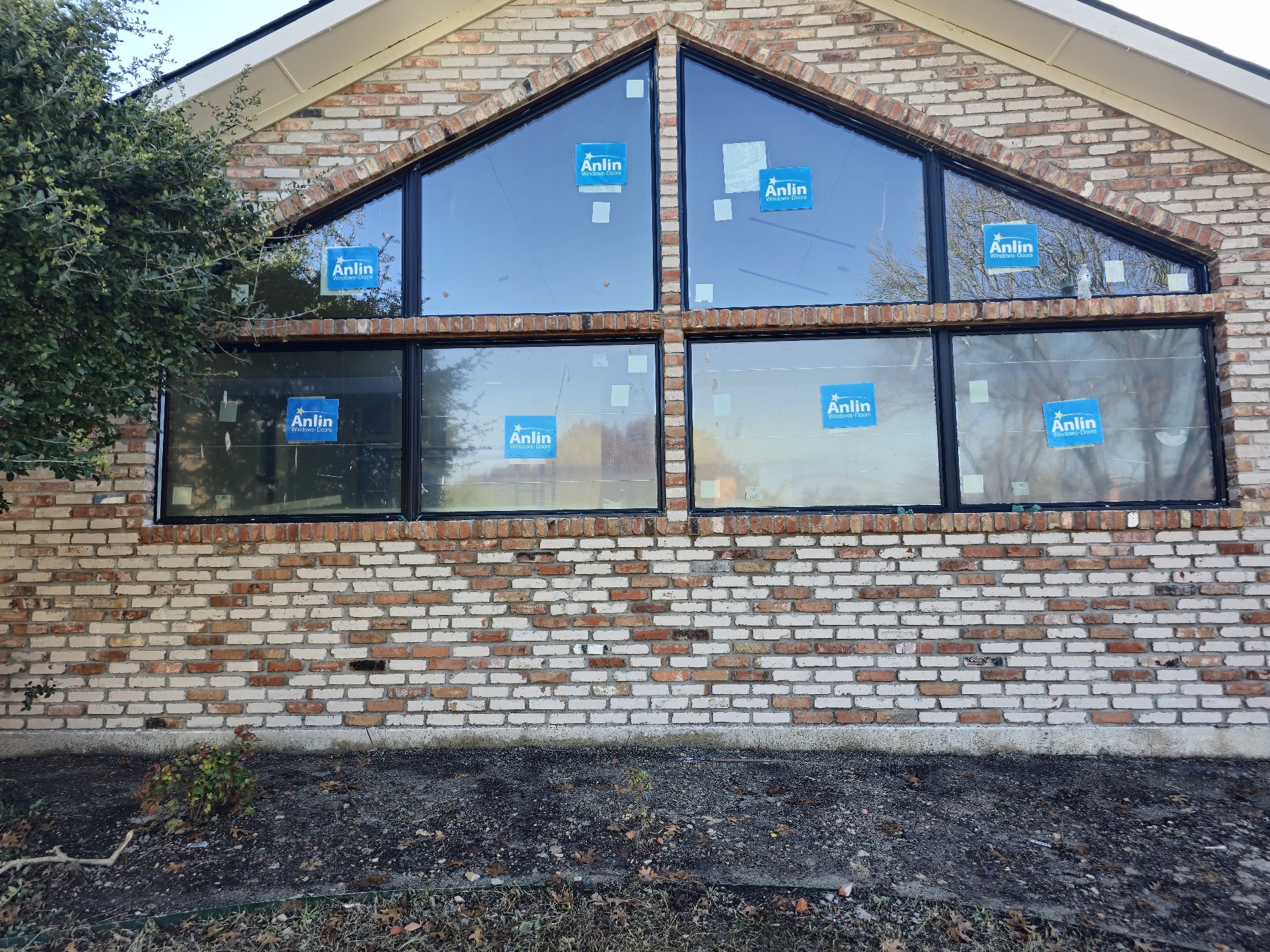 Willow Bend brick home with black Anlin replacement windows installed in a large gable wall