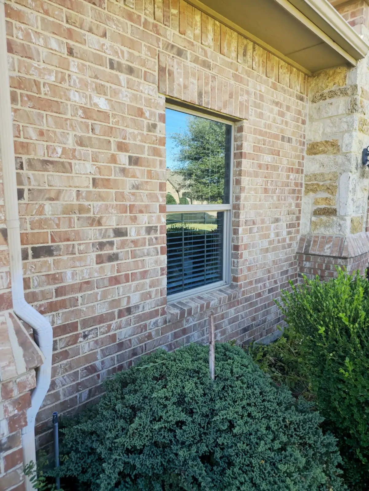 Single double-hung window with laminated security glass on a light-brick CityLine home