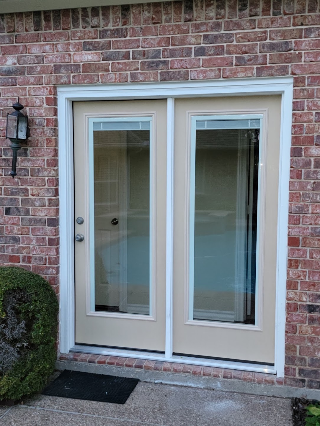 Exterior view of newly installed rear double doors on a Heath brick home
